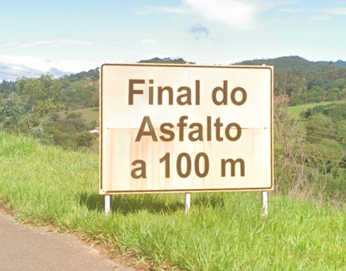 Placa de aviso de final de trecho pavimentado em direção à Serra da Canastra.